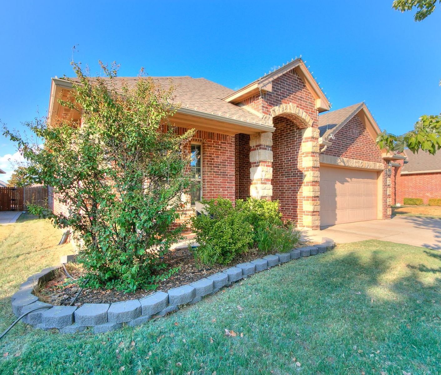 Brick and stone front of 1311 Skyler Way in Norman at sunset